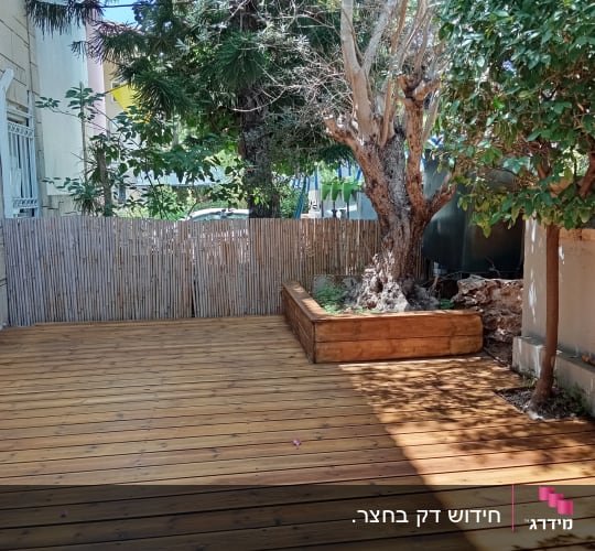 דק עץ עם עץ גדול וערוגה מוגבהת